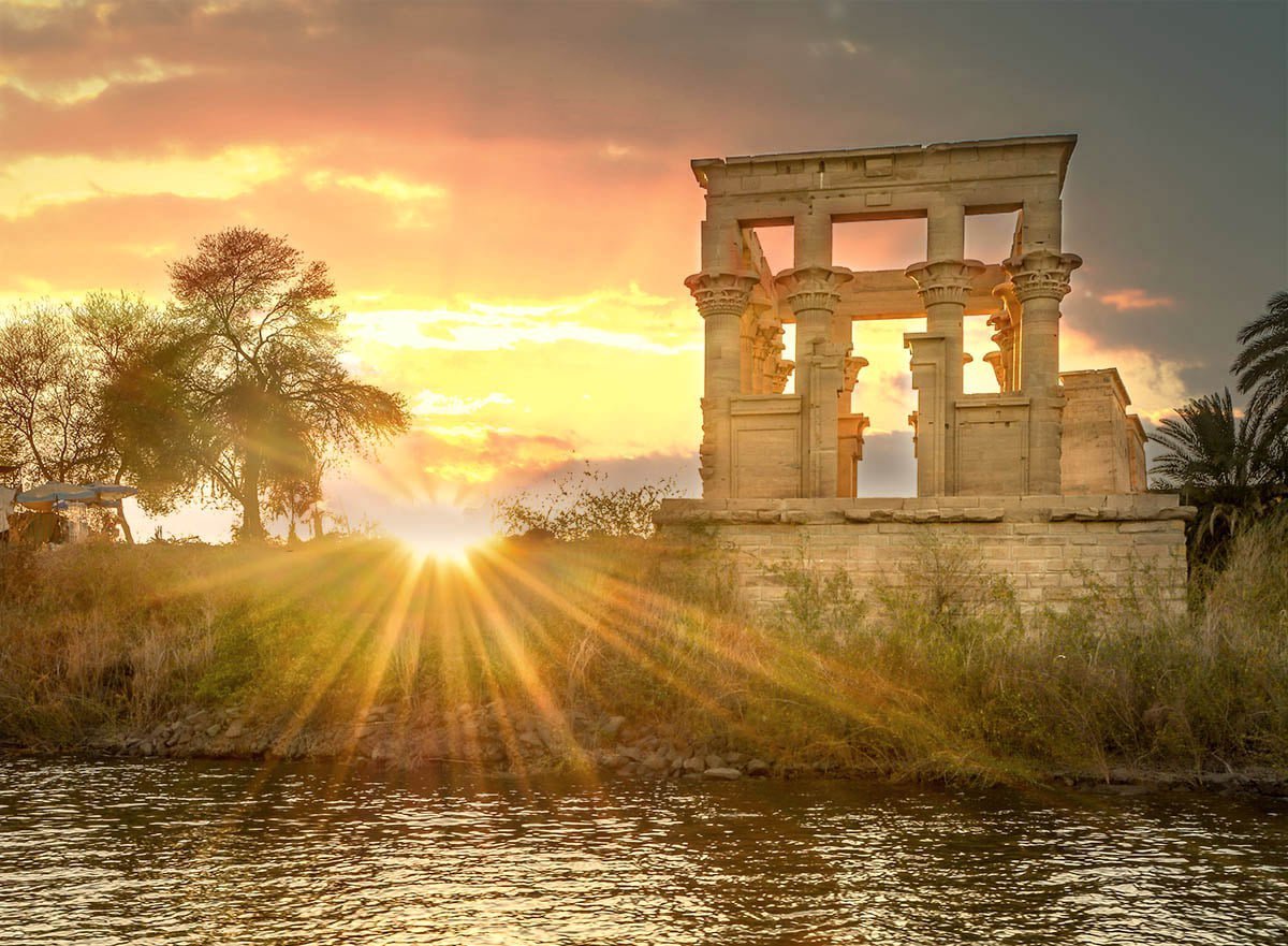 The Temples of Philae on Agilkia Island, featuring the majestic Temple of Isis surrounded by calm Nile waters and lush greenery.