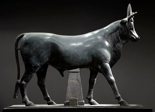 Ancient Egyptian depiction of the Bull God Apis, featuring sacred bull imagery with solar disc and hieroglyphic carvings.