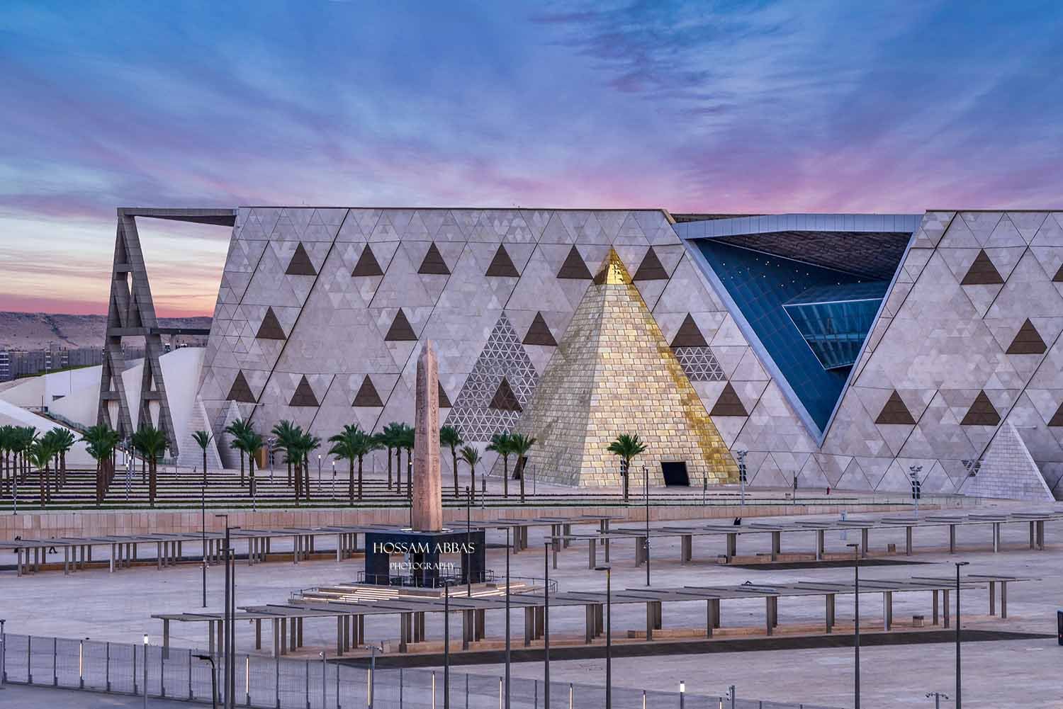 The Grand Egyptian Museum near the Giza Pyramids, featuring its modern architectural design, glass façade, and spacious plaza.